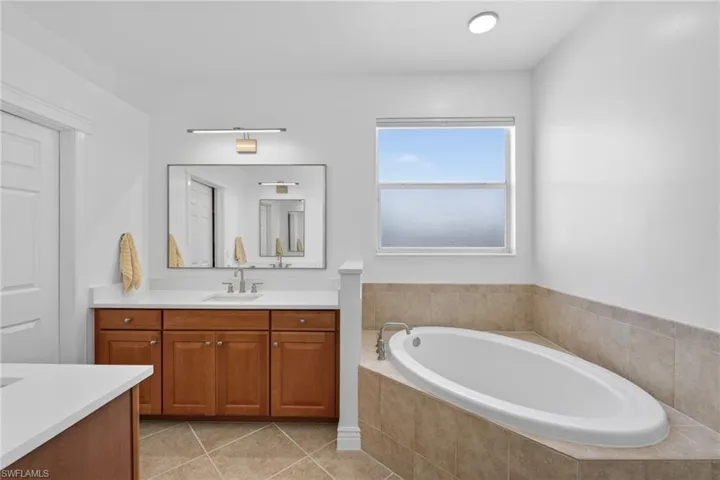 Full bath featuring hia and hers vanities, soaking tub, and seperate shower.