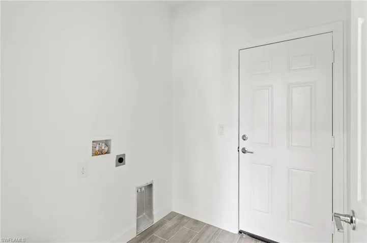 Clothes washing area with electric dryer hookup, light wood-type flooring, and washer hookup