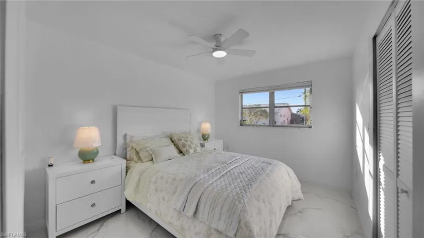 Bedroom with light marble finish flooring, a ceiling fan, and a closet