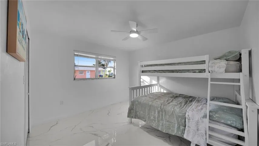Bedroom featuring marble finish flooring and a ceiling fan