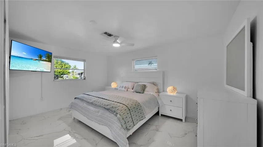 Bedroom featuring marble look tile flooring and ceiling fan