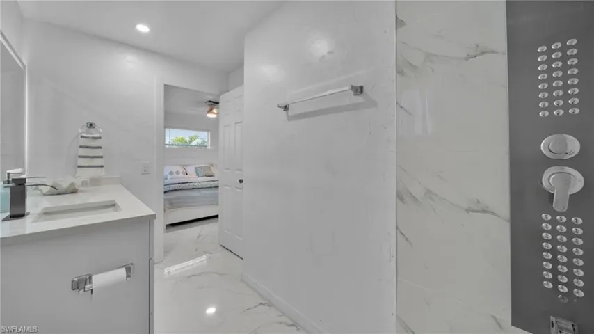 Bathroom with ensuite bathroom, vanity, light marble finish floors, recessed lighting, and a ceiling fan
