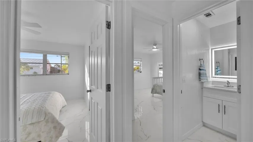 Ensuite bathroom featuring ceiling fan, light marble finish flooring, and vanity