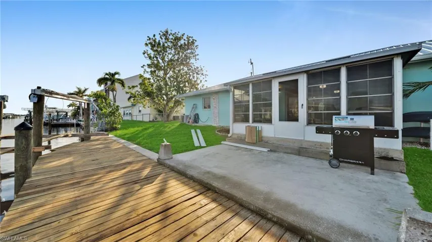 Back of property with a patio, a water view, and a sunroom