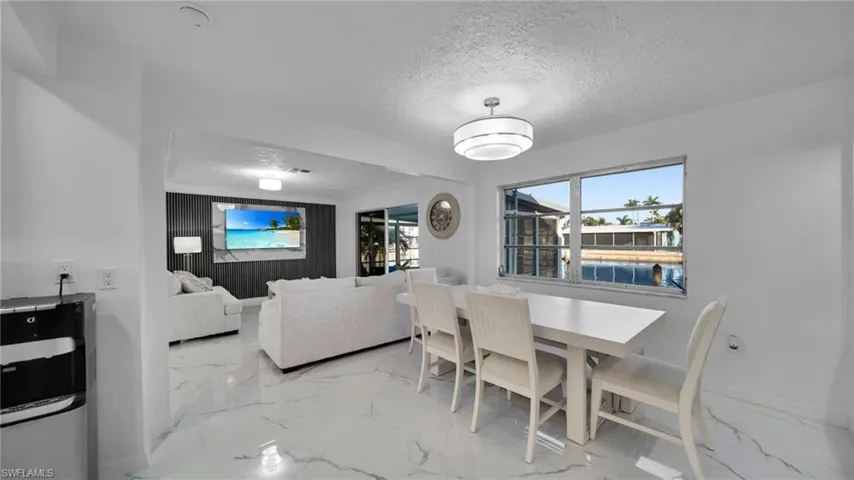 Dining area featuring light marble finish floors and a textured ceiling