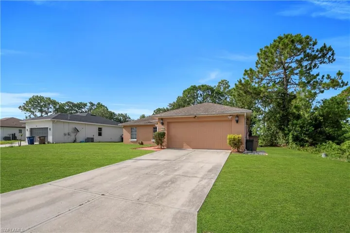 Single-story residence featuring a terracotta-hued exterior and an attached garage with a matching door