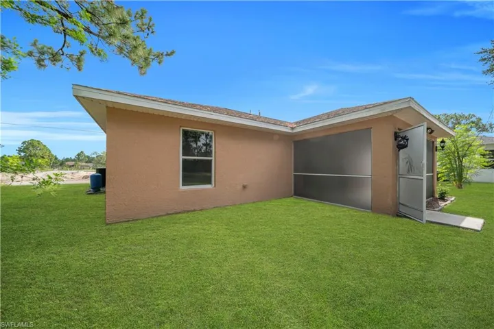 Expansive green lawn bordering a stucco exterior