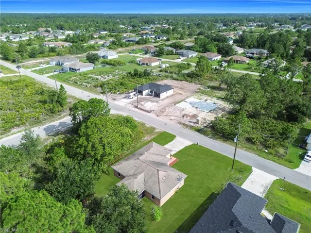 Aerial perspective showcasing a residential development with several established homes and new construction sites