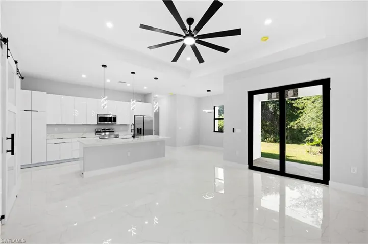 Kitchen with an island with sink, a barn door, and a tray ceiling
