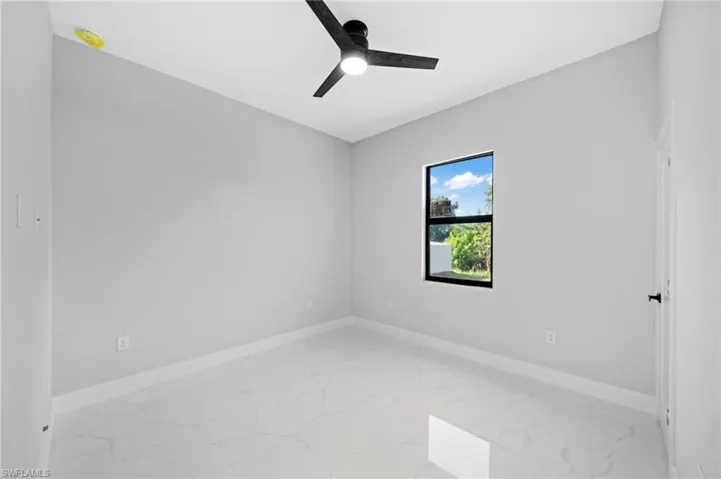 Spare room with ceiling fan and light tile floors
