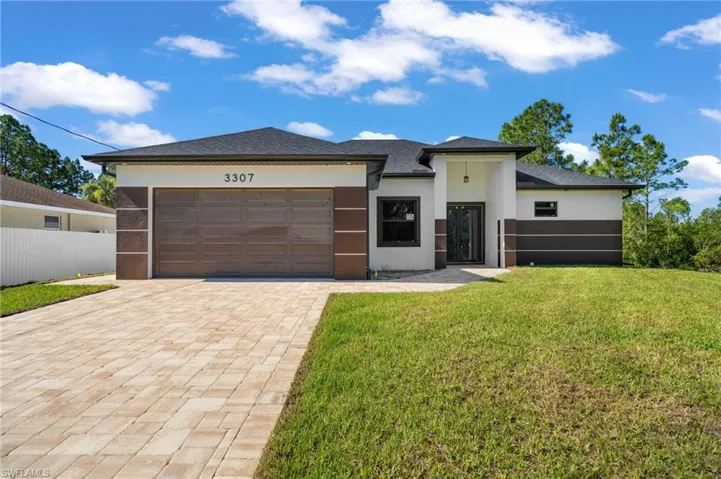 Prairie-style house featuring a front lawn and a garage