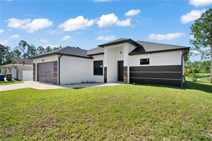 View of front of house featuring a garage and a front yard