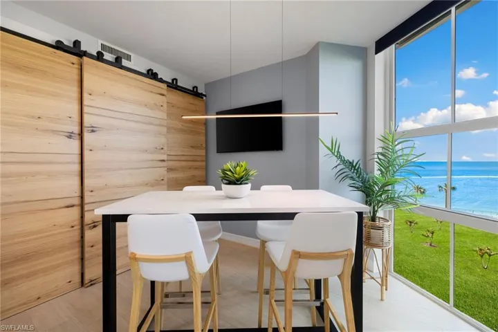 Dining space featuring light wood-type flooring, a barn door, plenty of natural light, and floor to ceiling windows