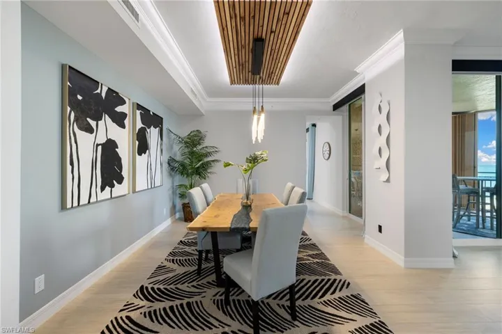 Dining space with light hardwood / wood-style floors and ornamental molding