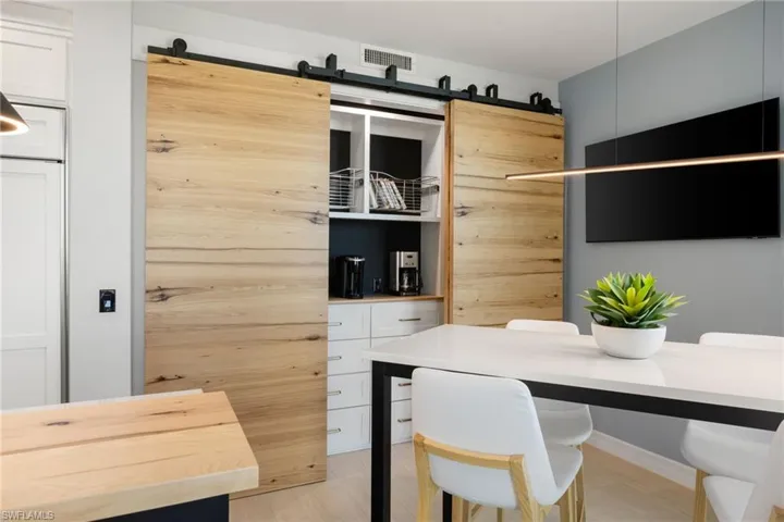 Wood barn door that slides to use as a hidden pantry for small applicances, shelving and plenty of cabinetry too