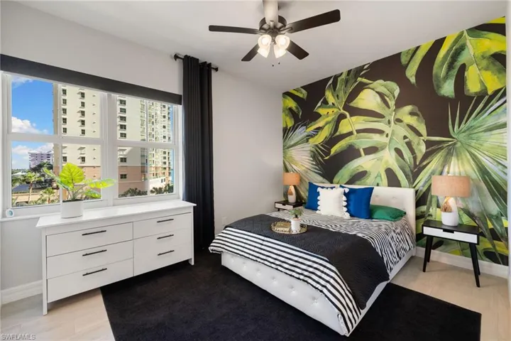 Guest bedroom with ceiling fan and light hardwood / wood-style floors