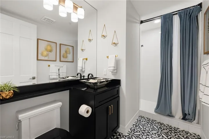 Bathroom featuring a shower with shower curtain, tile patterned flooring, and vanity