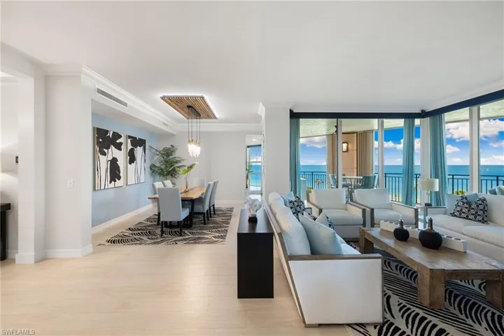 Family room featuring light wood-type flooring, a water view, a wall of windows, and crown molding