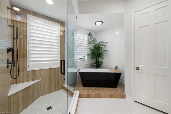 Primary bathroom with shower with separate bathtub and tile patterned floors