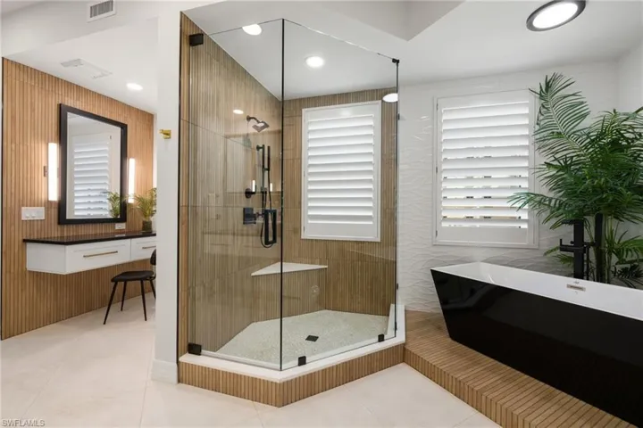 Primary bathroom with tile patterned floors, plenty of natural light, and shower with separate bathtub