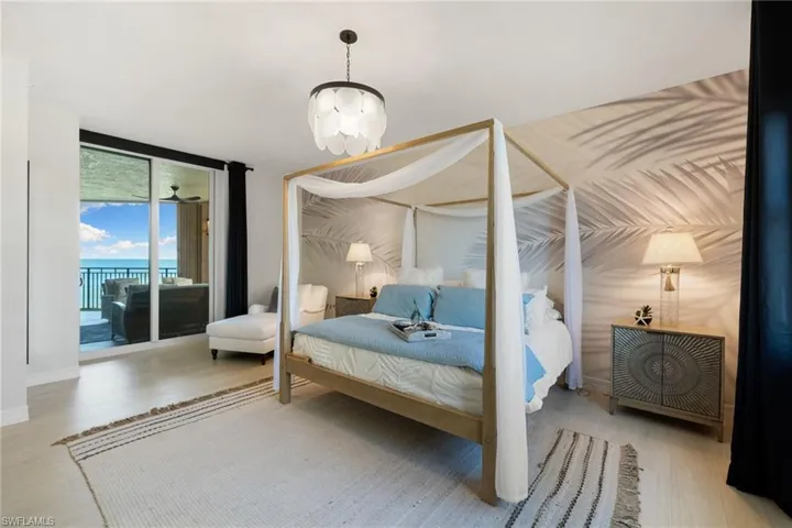 Primary bedroom with a chandelier, access to exterior, hardwood / wood-style flooring, and floor to ceiling windows