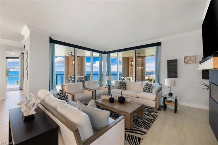 Family room with crown molding, light hardwood / wood-style flooring, a water view, and a healthy amount of sunlight