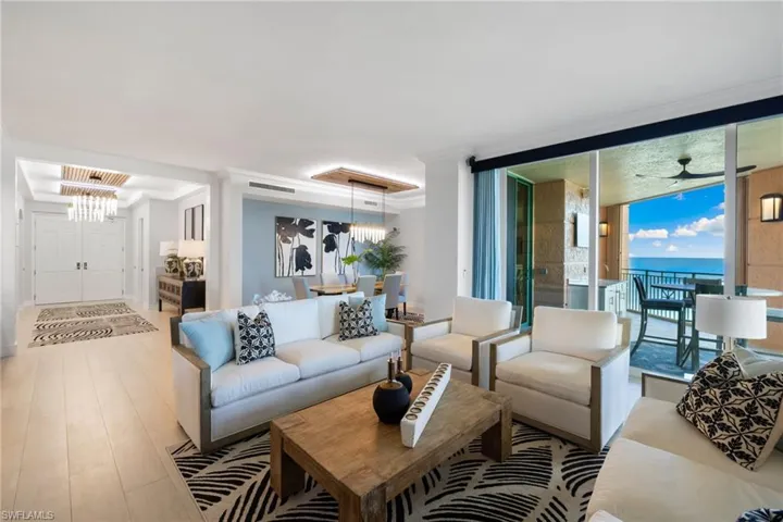 Family room with ceiling fan, expansive windows, crown molding, light hardwood / wood-style floors, and a water view