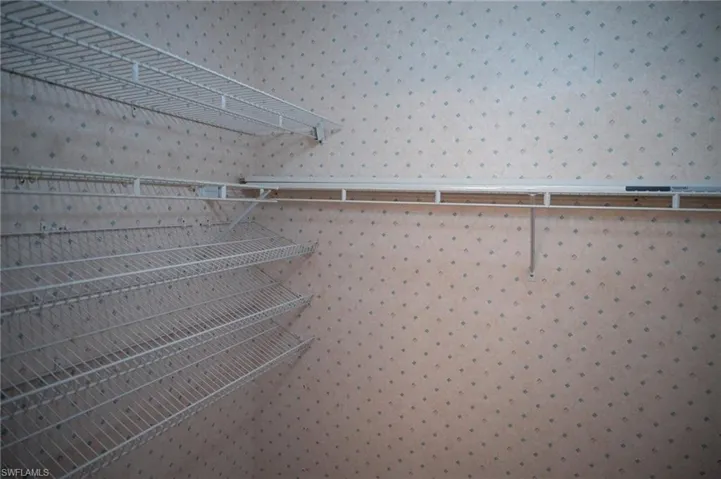 View of primary walk in closet shelving, primary bedroom