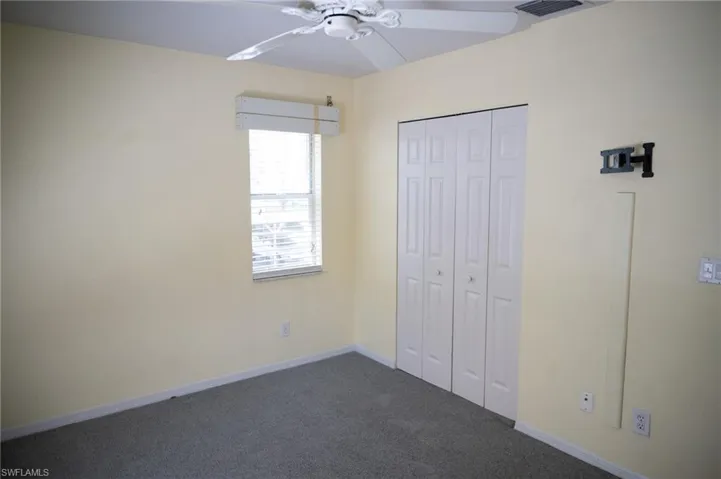 Unfurnished 2nd bedroom featuring carpet, a closet, and a ceiling fan