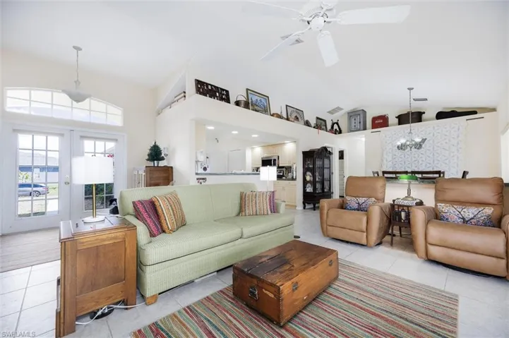 Living room features vaulted ceilings, and front double french doors with transom makes the room light and bright