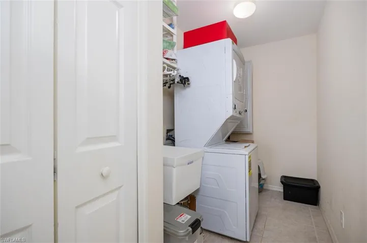 Laundry room features sink, closet and stacked washer/dryer
