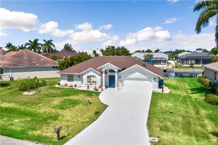 View of front of home featuring a front lawn, a garage, and a water view