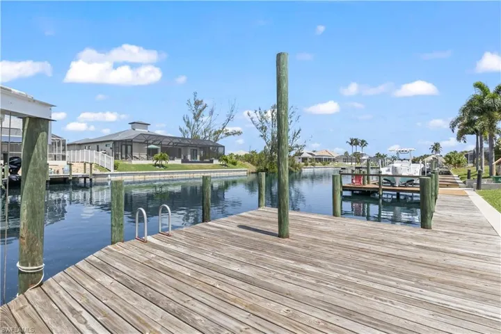 View of dock with a water view and a lanai