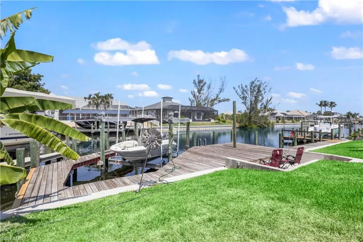 View of dock with a yard and a water view