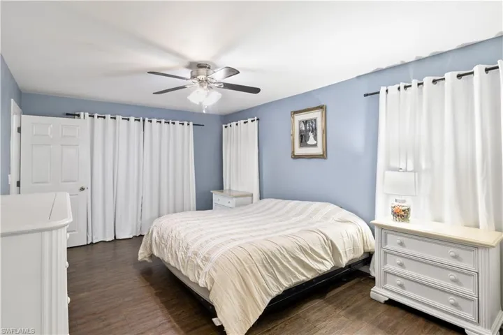 Bedroom with ceiling fan and dark hardwood / wood-style flooring