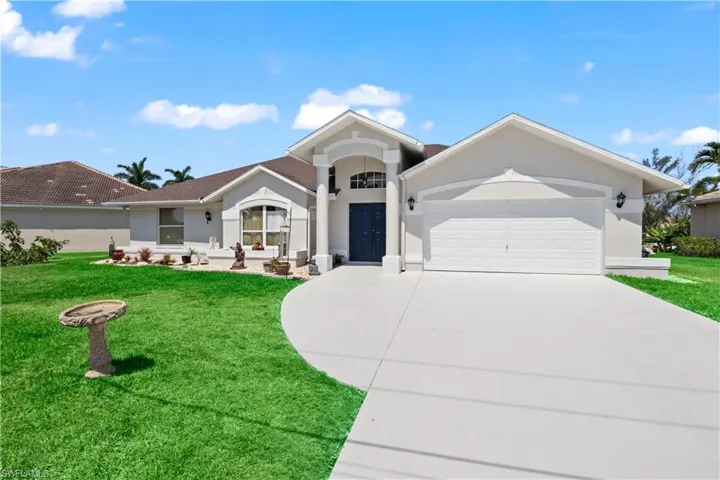 View of front of home featuring a front lawn and a garage