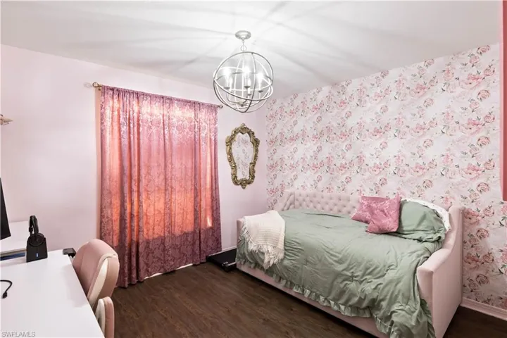 Bedroom with a notable chandelier and dark hardwood / wood-style floors