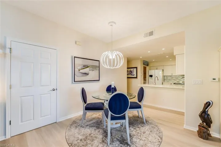 Dining room featuring light wood finished floors, baseboards, visible vents, a notable chandelier, and recessed lighting