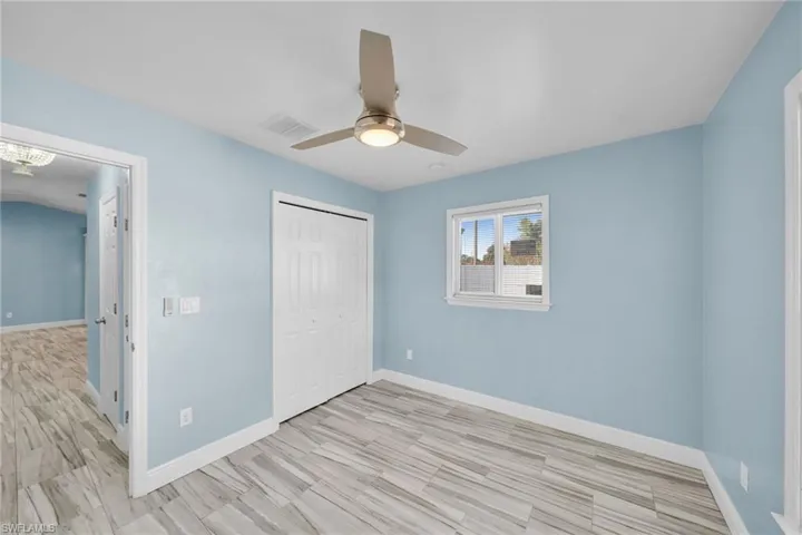 Unfurnished bedroom with a closet, ceiling fan, and light wood-style flooring