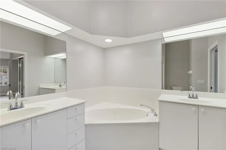 Bathroom featuring vanity, a bathtub, and toilet