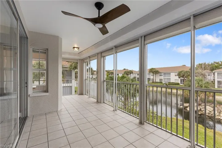 Unfurnished sunroom featuring a wealth of natural light, a water view, and ceiling fan