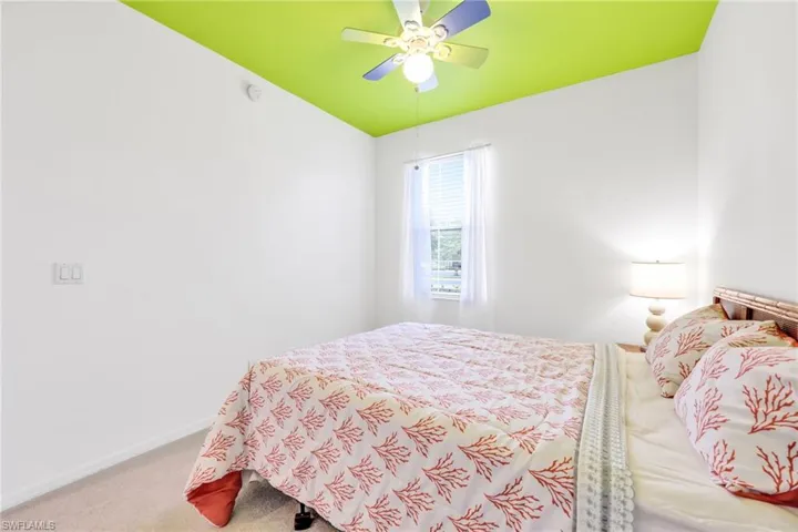 Carpeted bedroom featuring a ceiling fan and baseboards