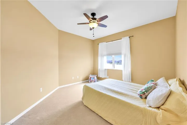 Carpeted bedroom with baseboards and ceiling fan