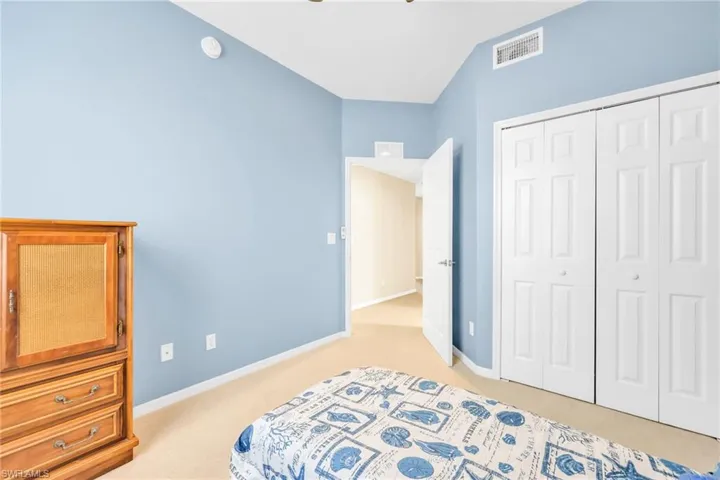 Bedroom with light carpet and a closet