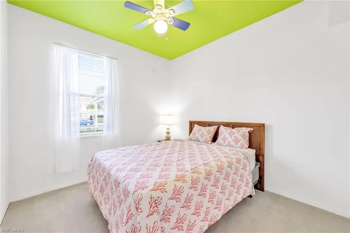 Carpeted bedroom featuring a ceiling fan and baseboards