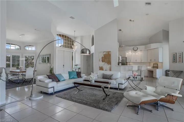 Living room featuring light tile patterned flooring and a towering ceiling
