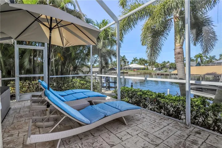 View of patio / terrace featuring glass enclosure and a water view