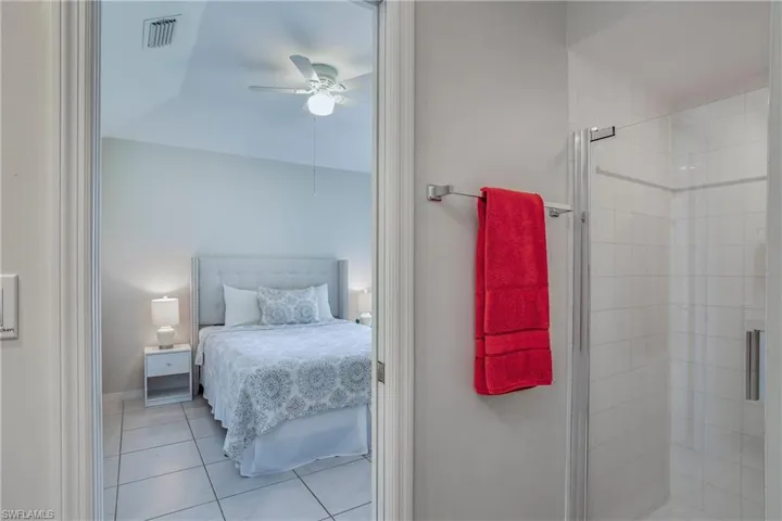 Tiled bedroom featuring ceiling fan