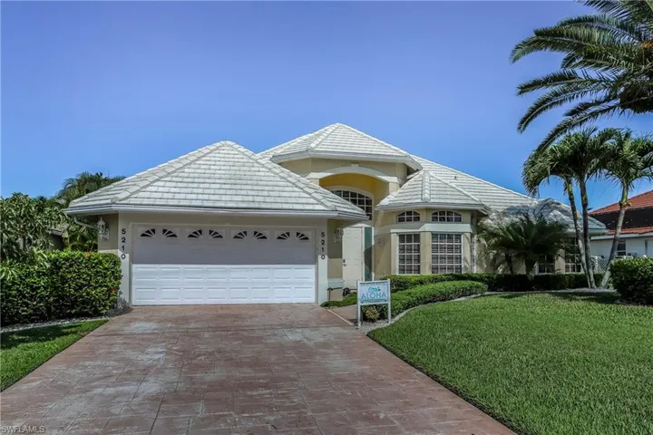 View of front of house featuring a front lawn and a garage