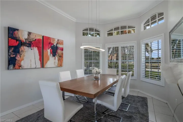 Tiled dining space featuring crown molding
